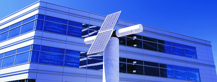 asset-monetization Daytime view of two solar panels mounted on a concrete pillar outside a modern building