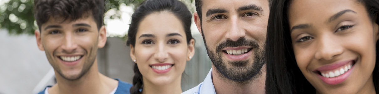 careers-header-2 Four people standing outside and smiling