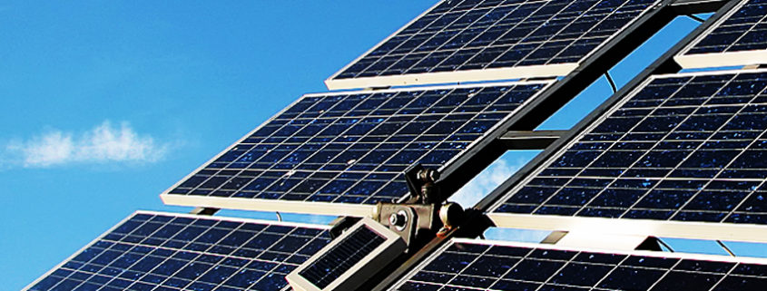 Closeup of six rack-mounted solar panels against a blue sky
