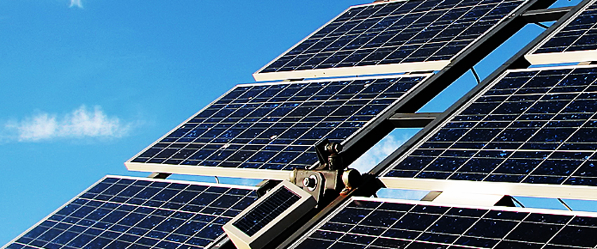 Closeup of six rack-mounted solar panels against a blue sky
