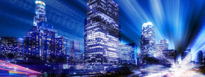 smart-cities-header-image Concept image for smart cities shows the downtown Los Angeles skyline at night with streams of binary data running through it