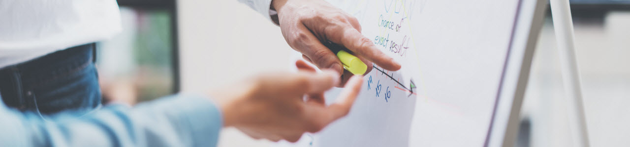 Concept image showing two hands pointing to data written on a whiteboard