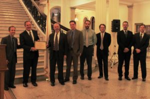 Massachusetts Department of Energy Resources Commissioner Mark Sylvia presents an award to representatives from the City of Lowell at the Massachusetts State House.