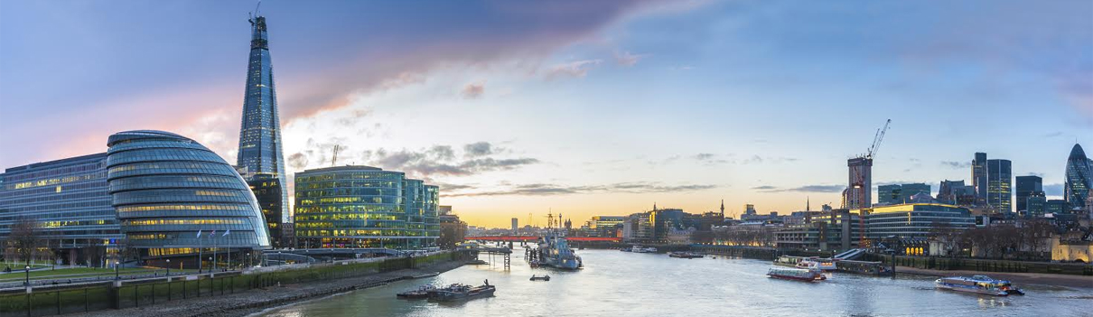 View of London at sunset from the Thames River, with the Shard on the left.