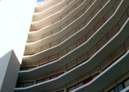 Close-up daytime exterior of railed porches on the front of a high rise residential building owned by the San Francisco Housing Authority