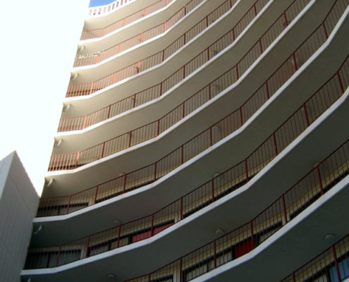 Close-up daytime exterior of railed porches on the front of a high rise residential building owned by the San Francisco Housing Authority