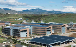 Daytime aerial view of National Renewable Energy Laboratories showing buildings and a large solar panel installaton