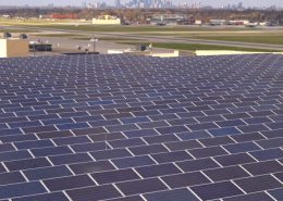 Daytime view of solar panels on the roof of St. Paul International Airport, with the City of Minneapolis on the horizon