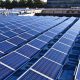 Daytime view of solar panels on the roof of a school building in Natick, Massachusetts