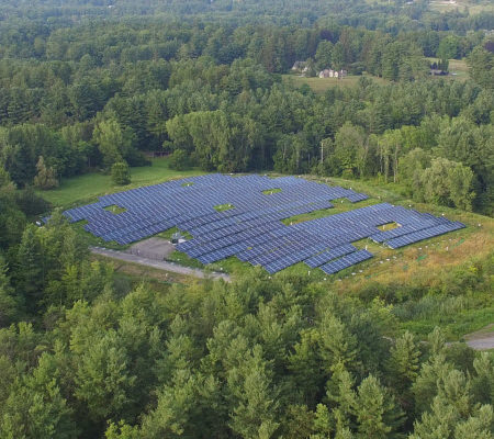 Daytime aerial view of a brownfield solar farm in Stockbridge.