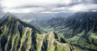 Daytime view of a valley in Hawaii bordered by jagged mountains