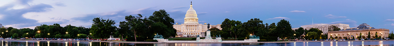 Daytime panoramic view of the United States Capitol Building seen from across its reflecting pool.