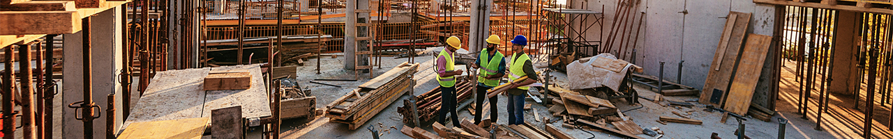 Daytime view of a group of workers on an unfinished upper floor of a building under construction