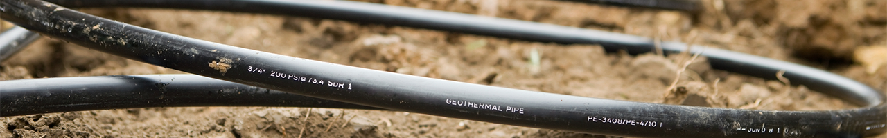 Daytime close up view of three-quarter-inch geothermal pipe in a trench