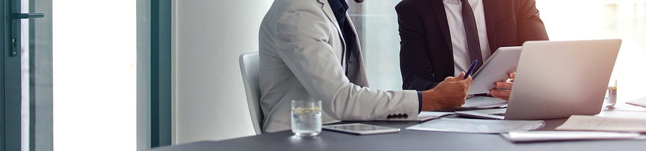 Close up interior view of two people in an office setting reviewing information on a computer