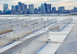 Daytime view of solar panels on the roof of Logan Airport with the City of Boston in the background