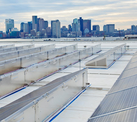 Daytime view of solar panels on the roof of Logan Airport with the City of Boston in the background