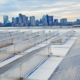 Daytime view of solar panels on the roof of Logan Airport with the City of Boston in the background