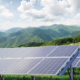 Daytime view of solar panels with mountains in background and blue sky