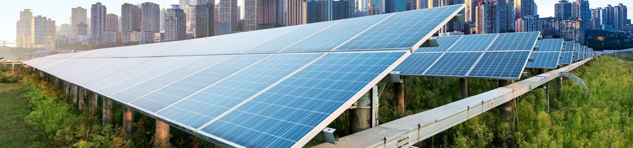 Daytime view of a solar panel array with a city skyline behind it