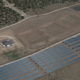 Daytime aerial view of land near Rocky Mountain College with rendered solar panels