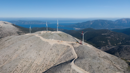 Daytime aerial view of wind turbines on a hilltop in Kefalonia, Greece