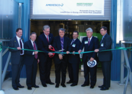 Daytime view of officials cutting a ribbon at the opening of an energy facility at the Jefferson County Landfill