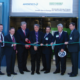 Daytime view of officials cutting a ribbon at the opening of an energy facility at the Jefferson County Landfill