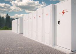 Daytime view of large-scale battery storage enclosures with an evergreen forest in the background