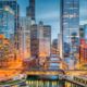 Downtown Chicago at sunset with buildings on either side of the river illuminated