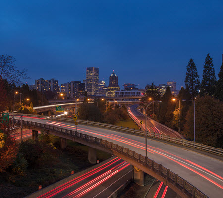 Evening view of the Portland, Oregon skyline with highways in the foreground