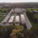 Daytime aerial view of solar carports overlaid with the text 4 Steps to Achieving Net Zero in a Building