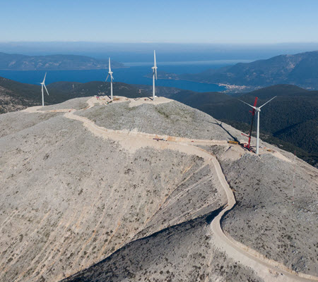 Daytime aerial view of wind turbines on a mountaintop in Kefalonia Greece