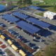 Daytime aerial view of solar car ports in a public school parking lot in Wayland Massachusetts