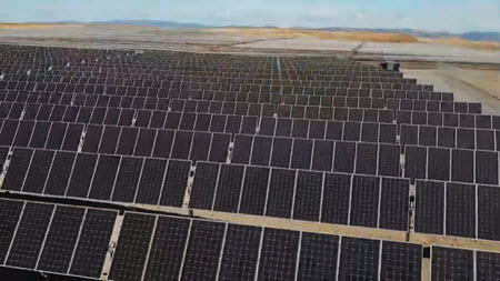 Daytime view of rows of solar panels in a San Joaquin brownfield solar farm