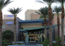 Daytime exterior of the main entrance of University Medical Center flanked by palm trees