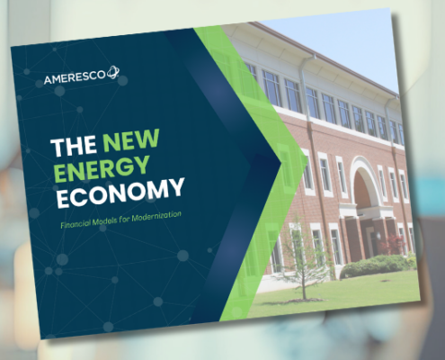 The cover of an Ameresco white paper entitled The New Energy Economy Financial Models for Modernization superimposed against a blurred image of an office worker at a desk in a modern high rise building