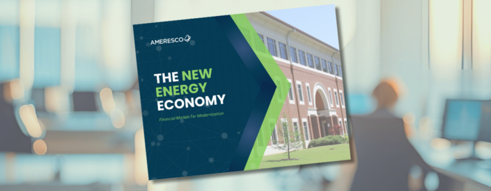 The cover of an Ameresco white paper entitled The New Energy Economy Financial Models for Modernization superimposed against a blurred image of an office worker at a desk in a modern high rise building