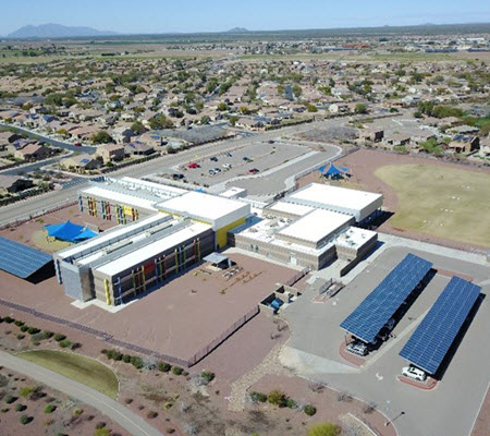 Daytime aerial view of solar car ports at a school building in the Marana Unified School District