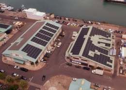 Daytime aerial view of Fresh Island Fish Company buildings with solar panels on the roof